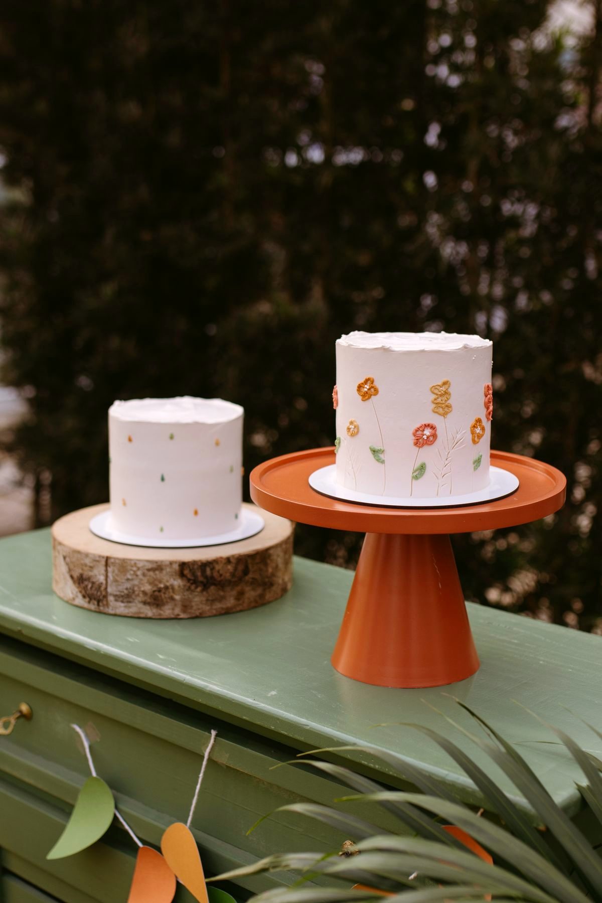 Two simple hand-decorated celebration cakes on stands
